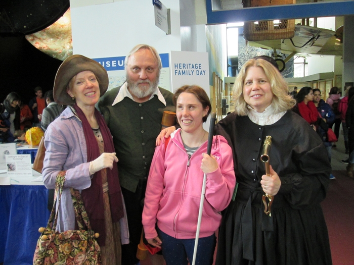 Three living history actors including Noreen Grice as Maria Mitchell, stand with a museum visitor.